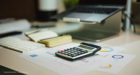 Unterlagen und Taschenrechner liegen auf dem Schreibtisch © Jakub Żerdzicki – unsplash.com